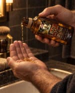 Homme versant la lotion tonique Bay Rum HONAE dans le creux de sa main devant un lavabo de salle de bain